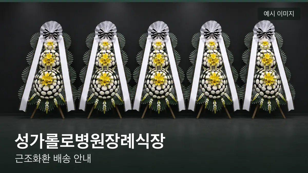 성가롤로병원장례식장 근조화환 예시 이미지 — 흰 국화 3단 근조화환이 벽을 따라 나란히 놓인 모습