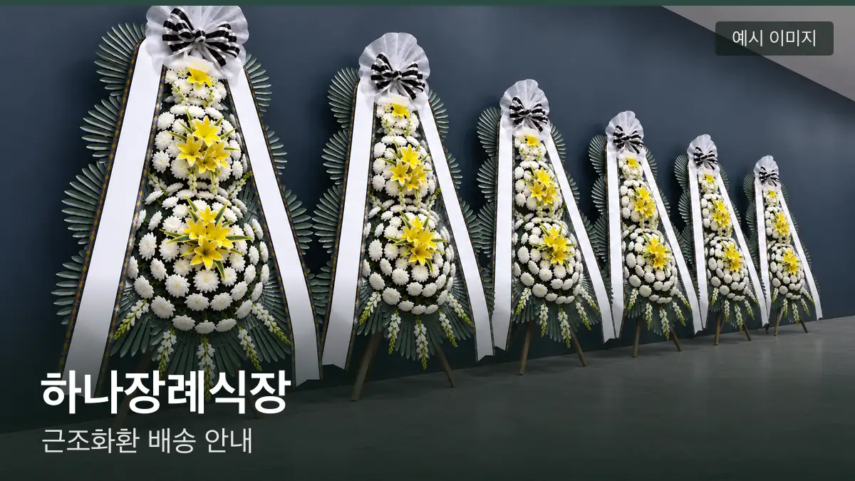 하나장례식장 근조화환 예시 이미지 — 흰 국화 3단 근조화환이 벽을 따라 나란히 놓인 모습