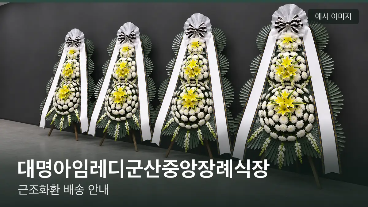 대명아임레디군산중앙장례식장 근조화환 예시 이미지 — 흰 국화 3단 근조화환이 벽을 따라 나란히 놓인 모습
