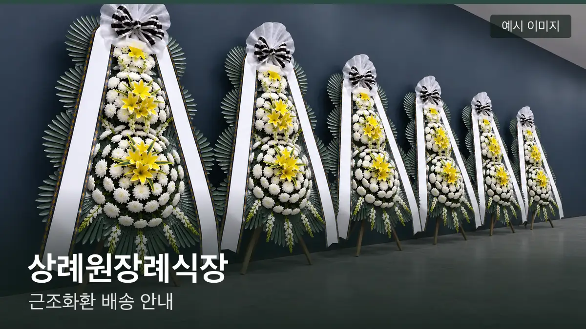 상례원장례식장 근조화환 예시 이미지 — 흰 국화 3단 근조화환이 벽을 따라 나란히 놓인 모습