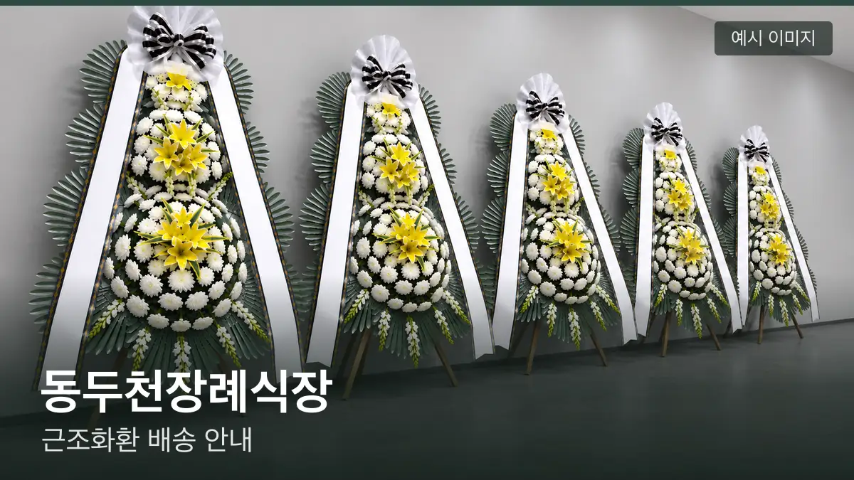 동두천장례식장 근조화환 예시 이미지 — 흰 국화 3단 근조화환이 벽을 따라 나란히 놓인 모습