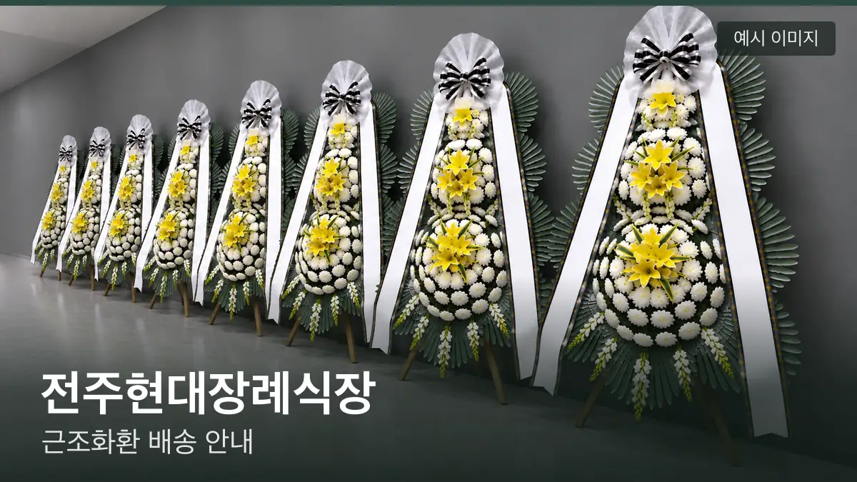 전주현대장례식장 근조화환 예시 이미지 — 흰 국화 3단 근조화환이 벽을 따라 나란히 놓인 모습