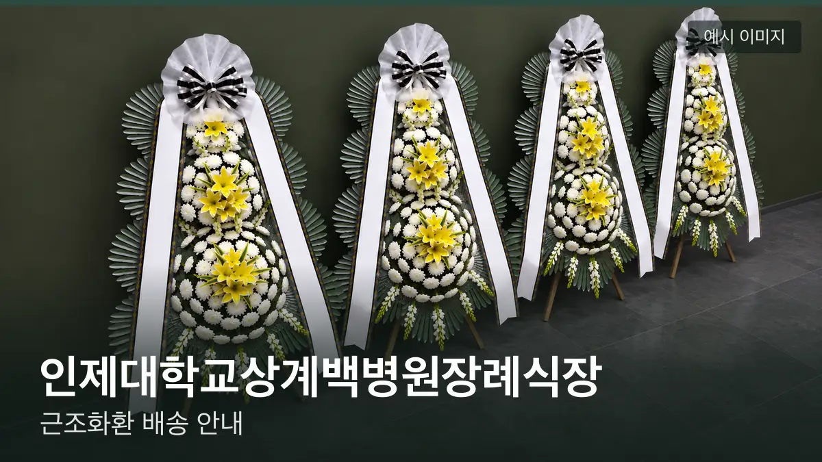 인제대학교상계백병원장례식장 근조화환 예시 이미지 — 흰 국화 3단 근조화환이 벽을 따라 나란히 놓인 모습