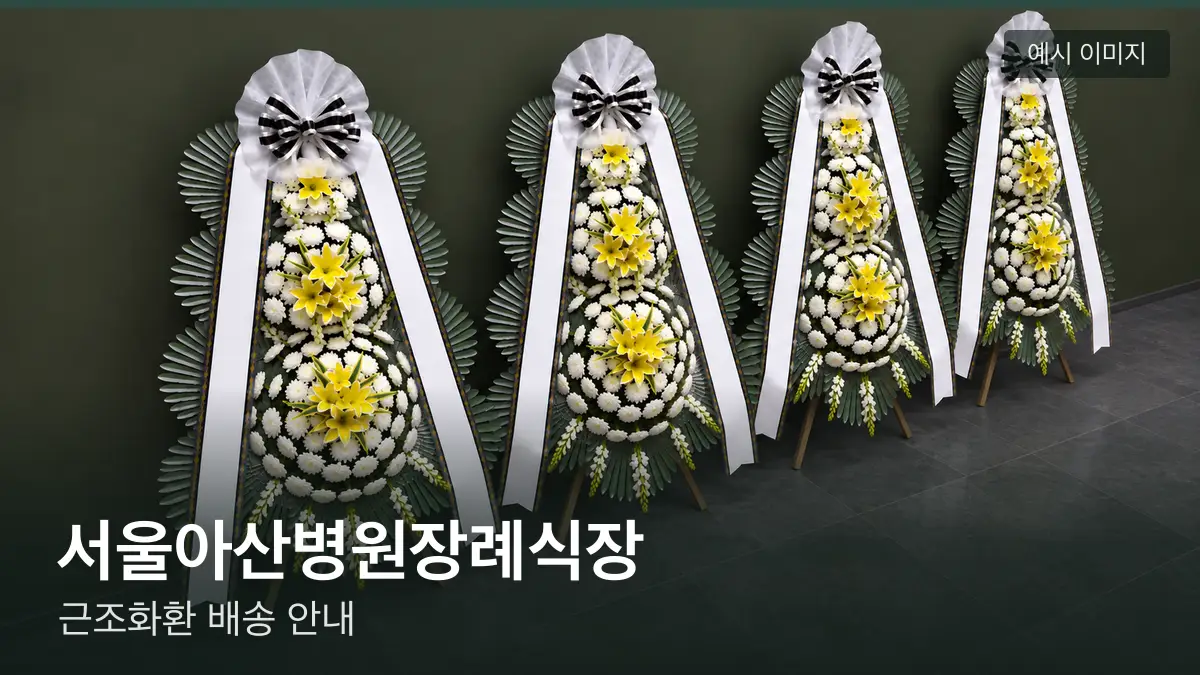 서울아산병원장례식장 근조화환 예시 이미지 — 흰 국화 3단 근조화환이 벽을 따라 나란히 놓인 모습