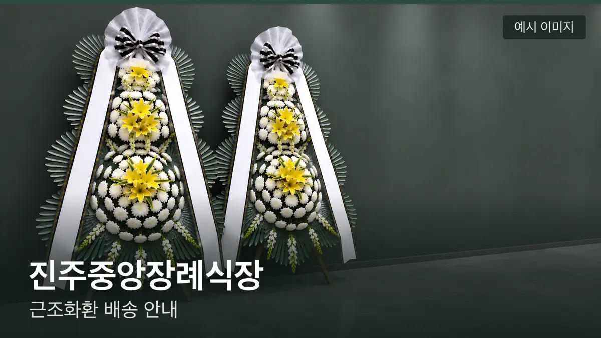 진주중앙장례식장 근조화환 예시 이미지 — 흰 국화 3단 근조화환이 벽을 따라 나란히 놓인 모습