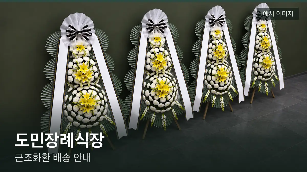 도민장례식장 근조화환 예시 이미지 — 흰 국화 3단 근조화환이 벽을 따라 나란히 놓인 모습