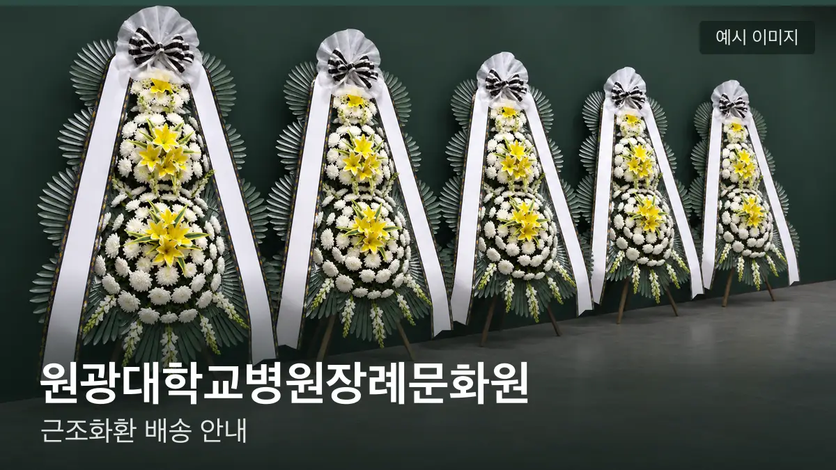 원광대학교병원장례문화원 근조화환 예시 이미지 — 흰 국화 3단 근조화환이 벽을 따라 나란히 놓인 모습