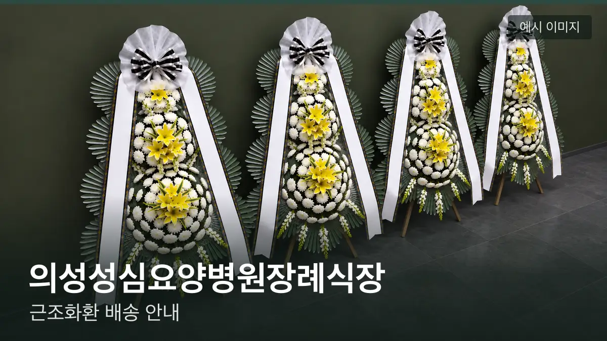 의성성심요양병원장례식장 근조화환 예시 이미지 — 흰 국화 3단 근조화환이 벽을 따라 나란히 놓인 모습