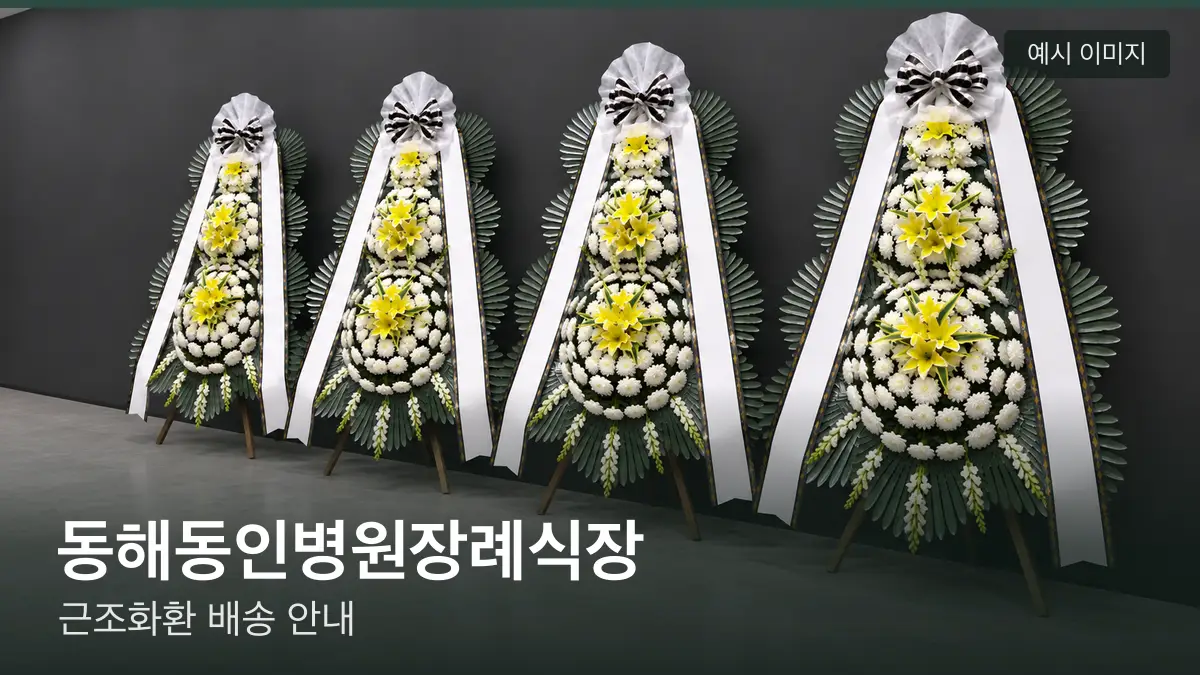 동해동인병원장례식장 근조화환 예시 이미지 — 흰 국화 3단 근조화환이 벽을 따라 나란히 놓인 모습