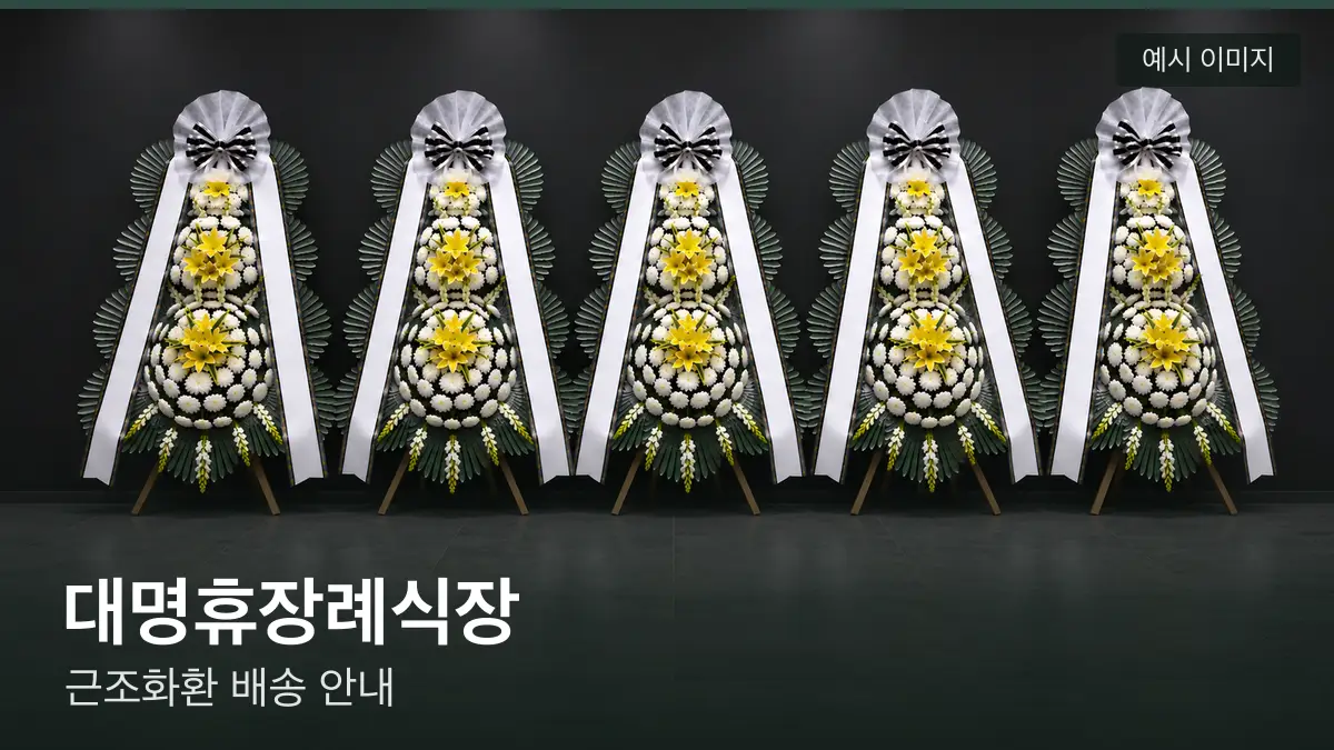 대명휴장례식장 근조화환 예시 이미지 — 흰 국화 3단 근조화환이 벽을 따라 나란히 놓인 모습