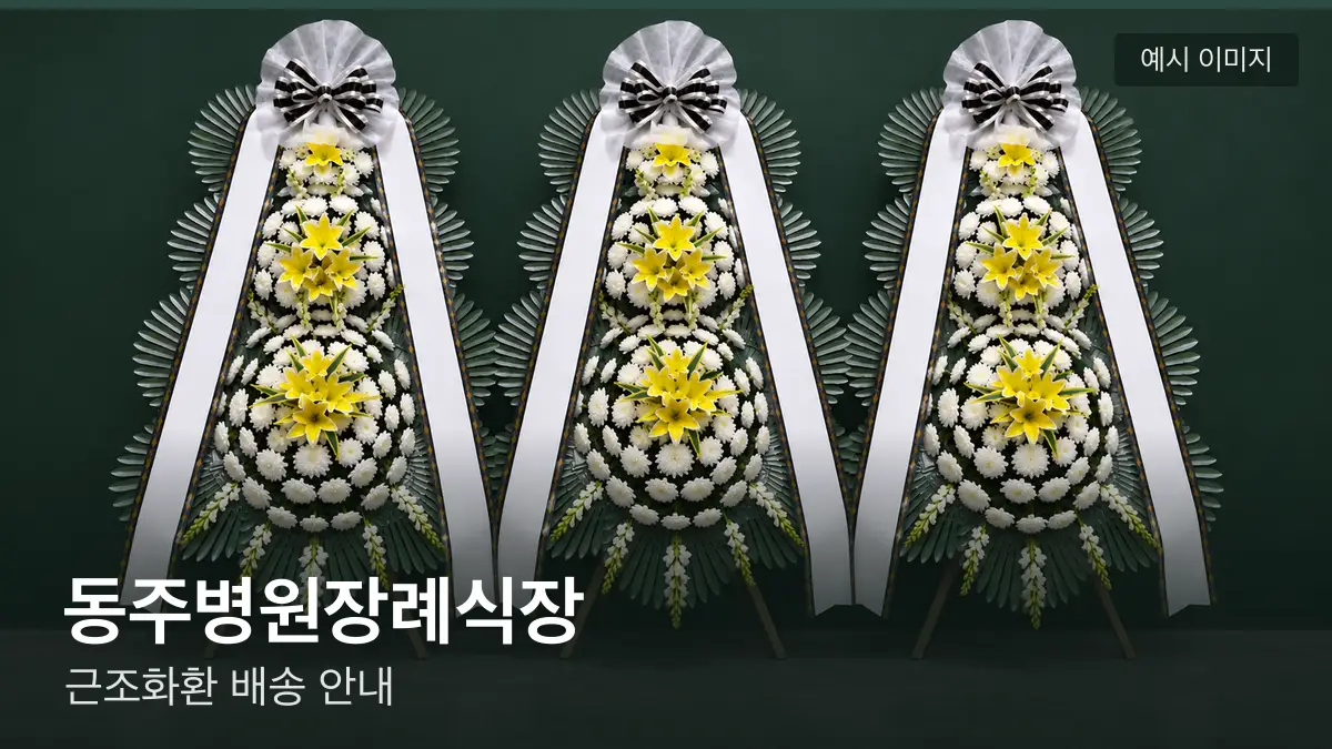 동주병원장례식장 근조화환 예시 이미지 — 흰 국화 3단 근조화환이 벽을 따라 나란히 놓인 모습