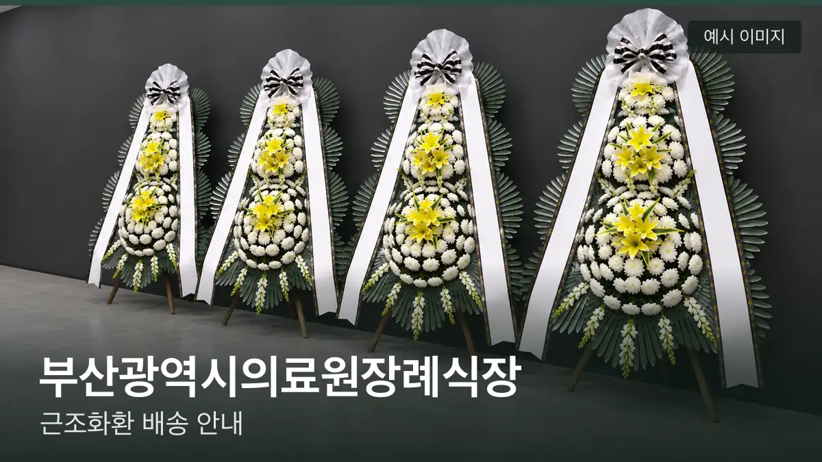 부산광역시의료원장례식장 근조화환 예시 이미지 — 흰 국화 3단 근조화환이 벽을 따라 나란히 놓인 모습