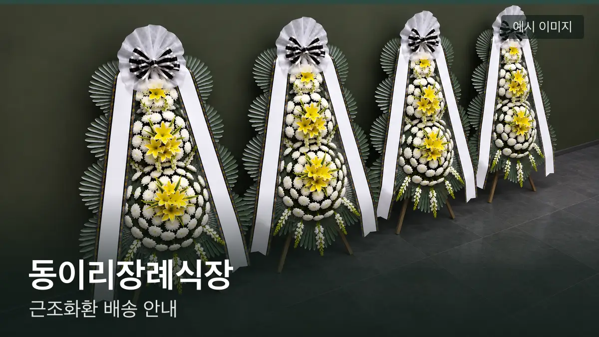 동이리장례식장 근조화환 예시 이미지 — 흰 국화 3단 근조화환이 벽을 따라 나란히 놓인 모습