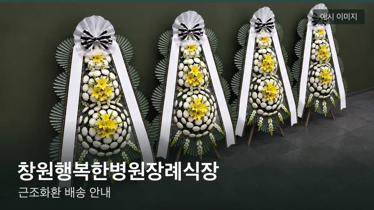 창원행복한병원장례식장 근조화환 예시 이미지 — 흰 국화 3단 근조화환이 벽을 따라 나란히 놓인 모습