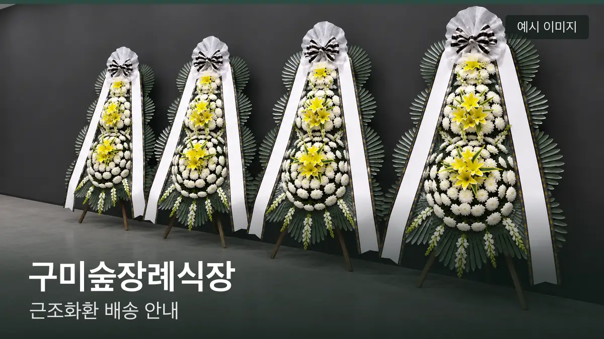 구미숲장례식장 근조화환 예시 이미지 — 흰 국화 3단 근조화환이 벽을 따라 나란히 놓인 모습