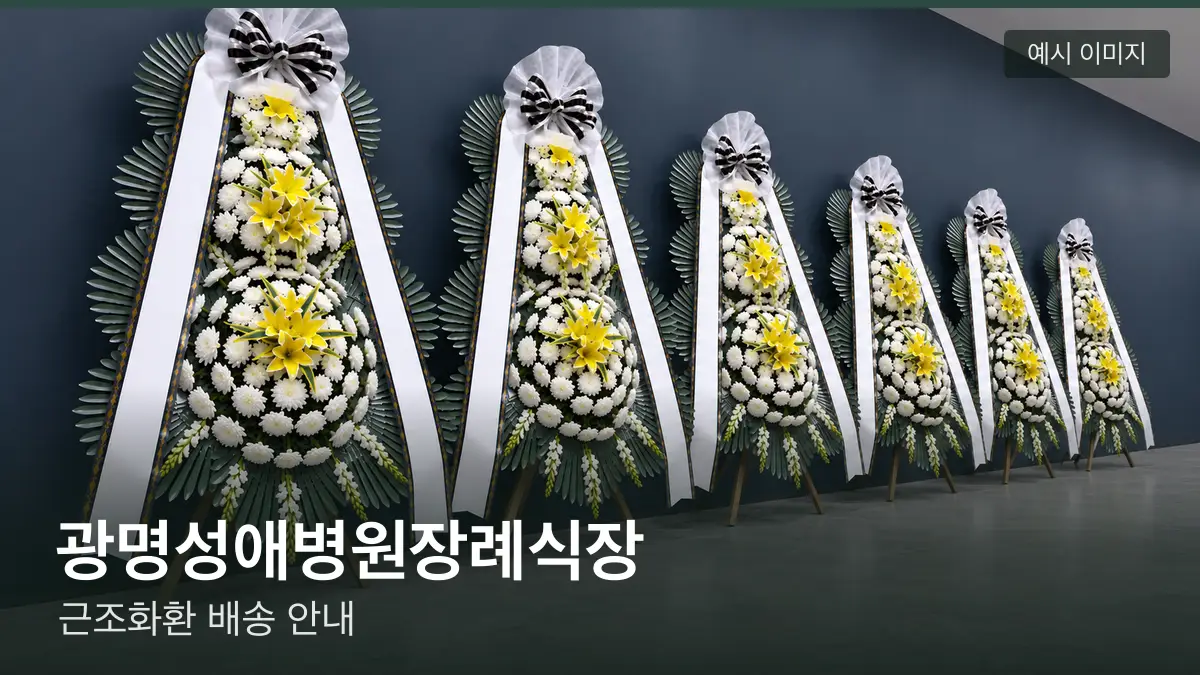 광명성애병원장례식장 근조화환 예시 이미지 — 흰 국화 3단 근조화환이 벽을 따라 나란히 놓인 모습