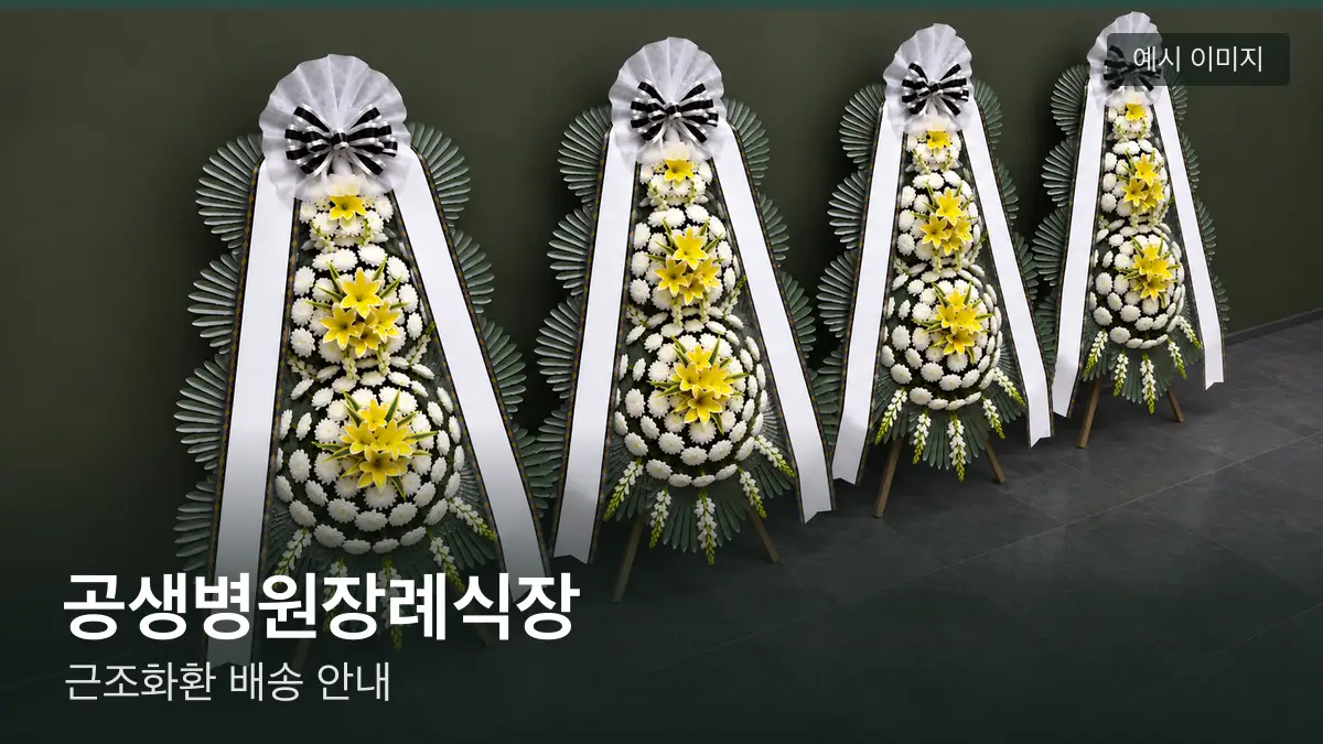 공생병원장례식장 근조화환 예시 이미지 — 흰 국화 3단 근조화환이 벽을 따라 나란히 놓인 모습