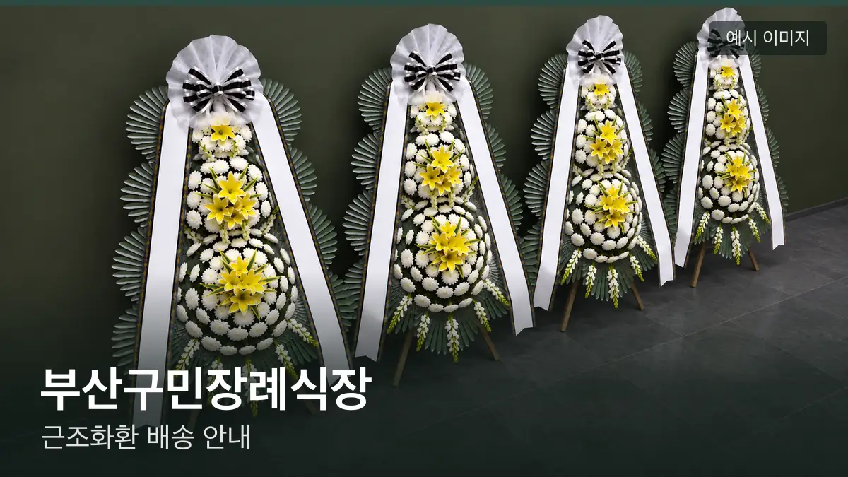 부산구민장례식장 근조화환 예시 이미지 — 흰 국화 3단 근조화환이 벽을 따라 나란히 놓인 모습