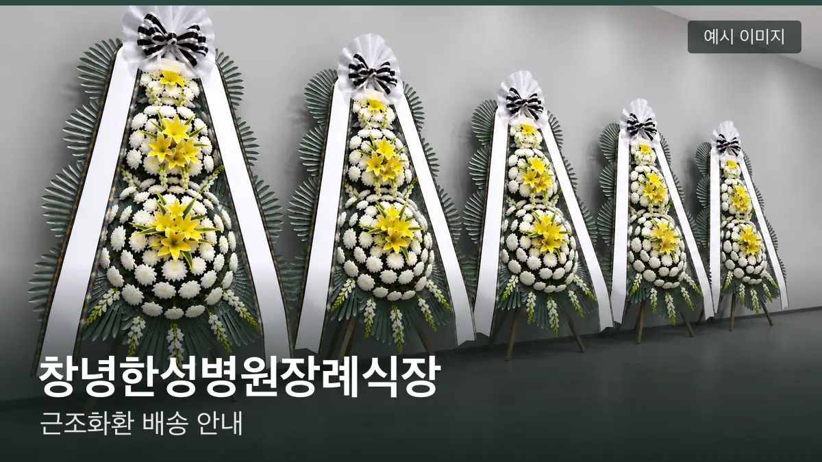 창녕한성병원장례식장 근조화환 예시 이미지 — 흰 국화 3단 근조화환이 벽을 따라 나란히 놓인 모습