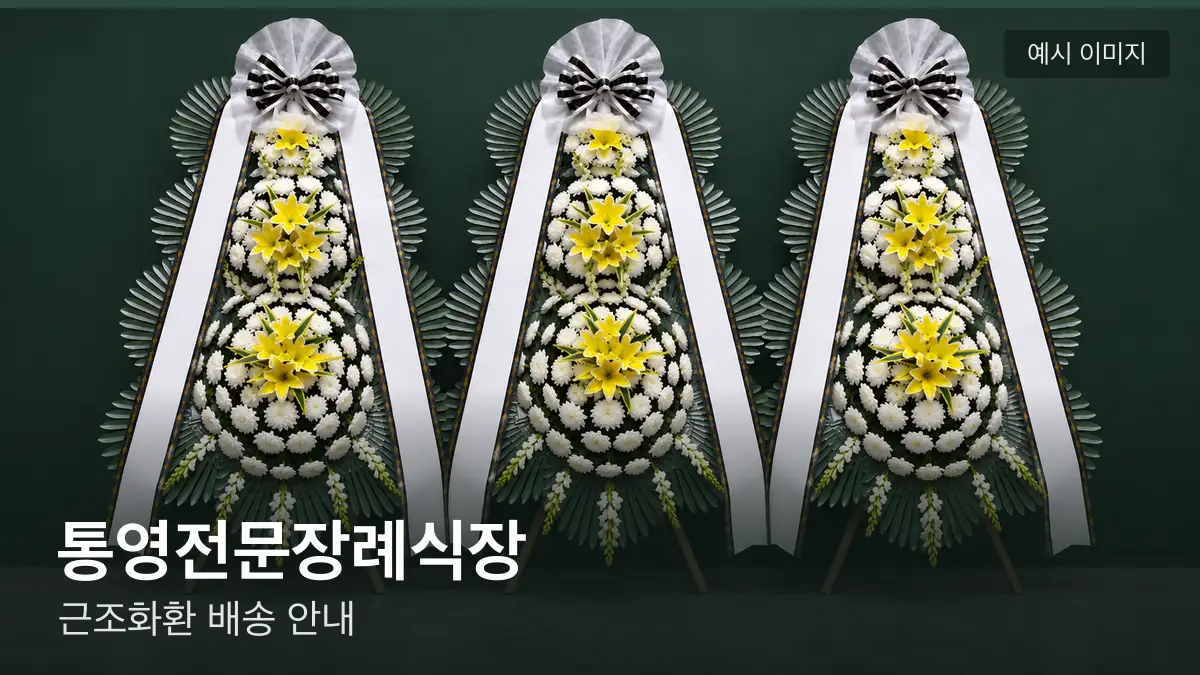 통영전문장례식장 근조화환 예시 이미지 — 흰 국화 3단 근조화환이 벽을 따라 나란히 놓인 모습